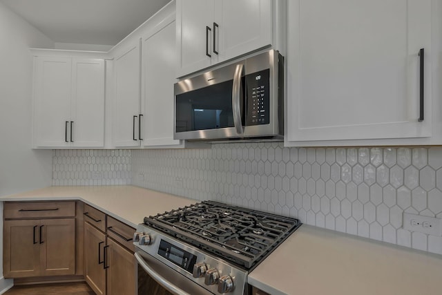 kitchen featuring white cabinetry, appliances with stainless steel finishes, dark hardwood / wood-style flooring, and decorative backsplash