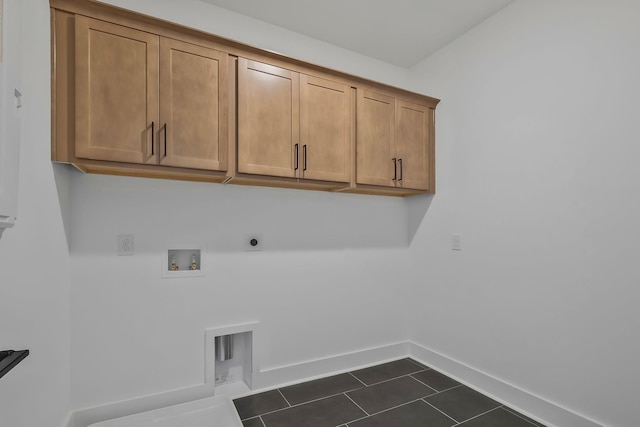 clothes washing area featuring cabinets, washer hookup, hookup for an electric dryer, and dark tile patterned flooring