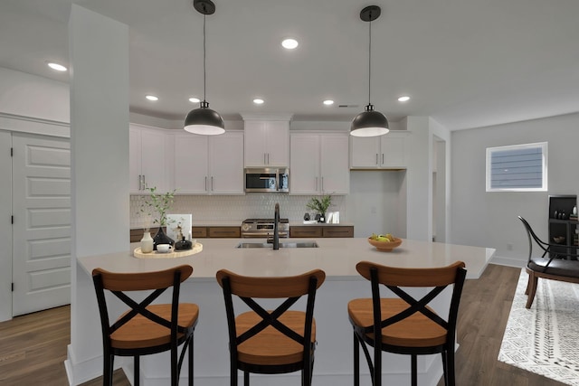 kitchen featuring white cabinetry, sink, pendant lighting, and appliances with stainless steel finishes