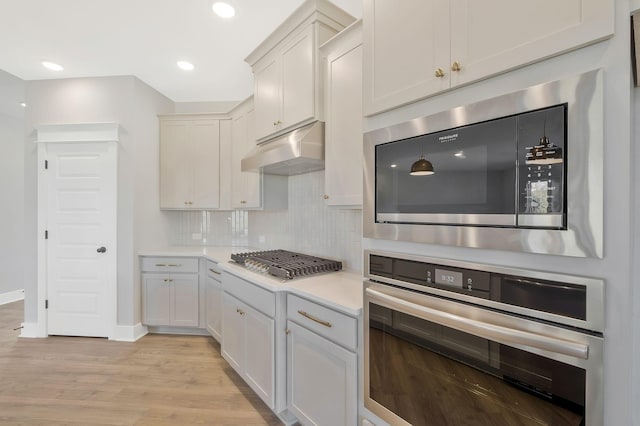 kitchen featuring pendant lighting, white cabinetry, tasteful backsplash, and stainless steel appliances