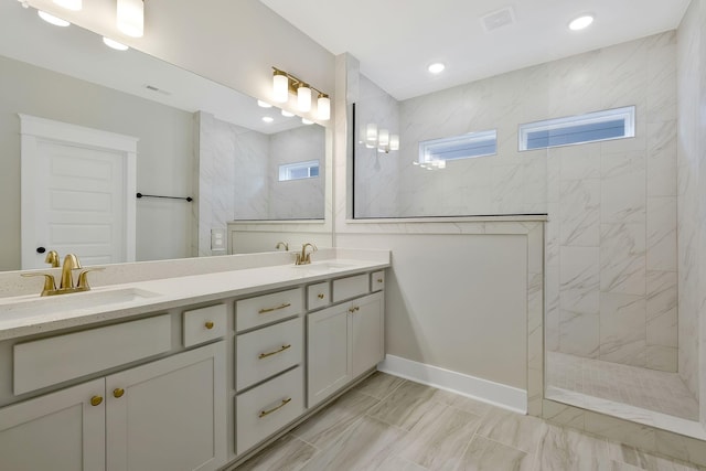 bathroom with tiled shower and vanity