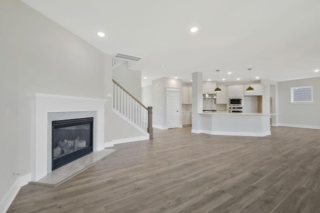 unfurnished living room featuring a premium fireplace and hardwood / wood-style floors