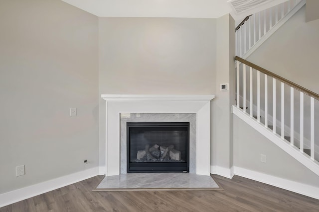 interior details with hardwood / wood-style flooring and a high end fireplace