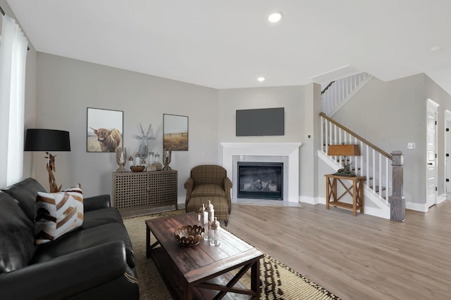 living room featuring wood-type flooring and a high end fireplace