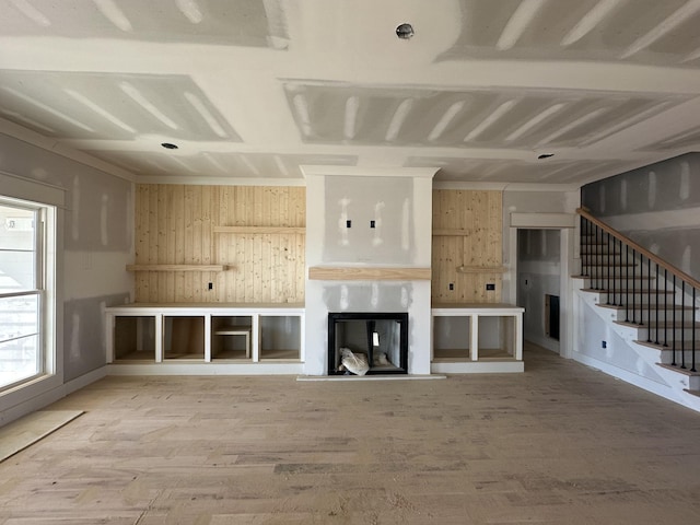 unfurnished living room with wood-type flooring and wood walls