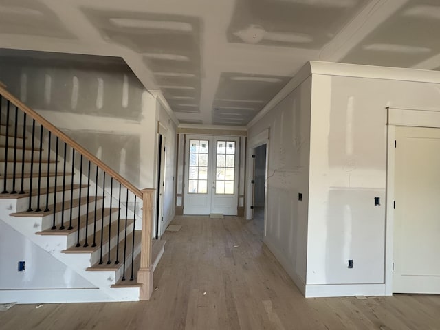 foyer entrance with french doors and light hardwood / wood-style flooring