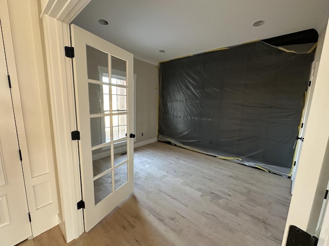 interior space with french doors, baseboards, and wood finished floors