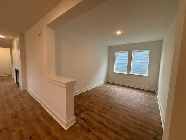 empty room with dark hardwood / wood-style floors and a fireplace