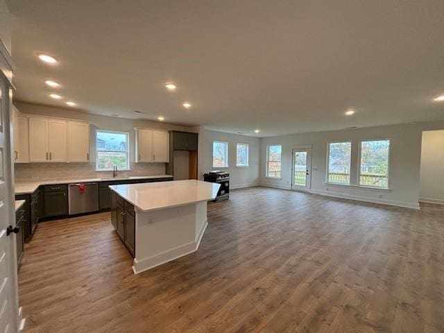 kitchen with a center island, wood-type flooring, dishwasher, and white cabinets