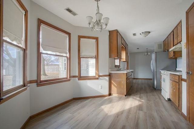 kitchen featuring white range with electric cooktop, a chandelier, hanging light fixtures, and light wood-type flooring