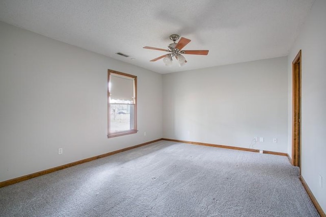 carpeted spare room featuring ceiling fan and a textured ceiling