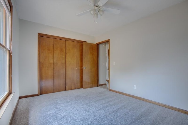 unfurnished bedroom with light carpet, ceiling fan, and a closet