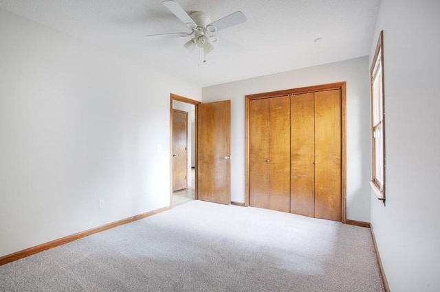 unfurnished bedroom with light colored carpet, ceiling fan, and a closet