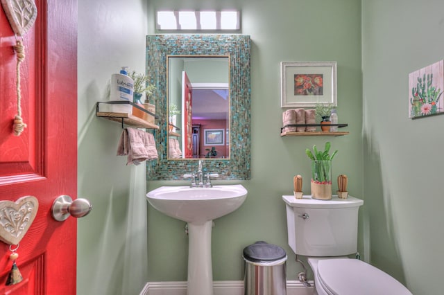 bathroom featuring backsplash and toilet