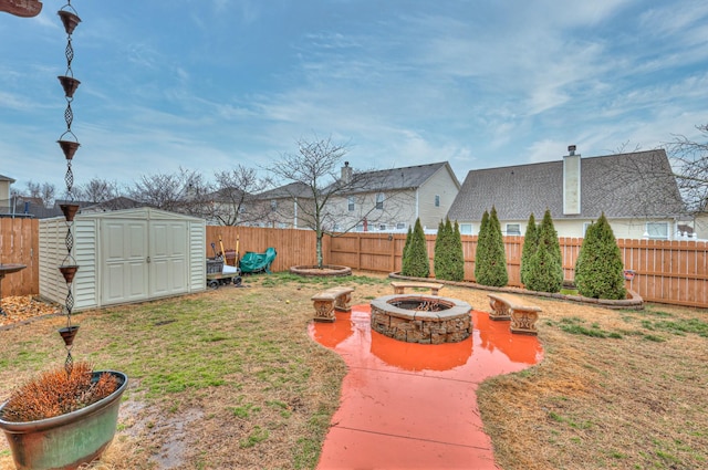 view of yard featuring a patio, a storage unit, and an outdoor fire pit