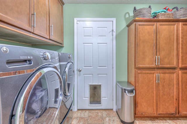 clothes washing area featuring washer and clothes dryer, cabinets, and a textured ceiling