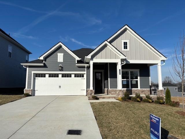 craftsman inspired home featuring a garage, a front lawn, and a porch