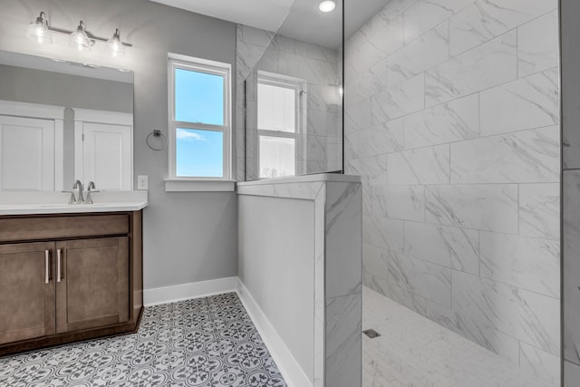 full bathroom featuring tile patterned flooring, baseboards, vanity, and a walk in shower