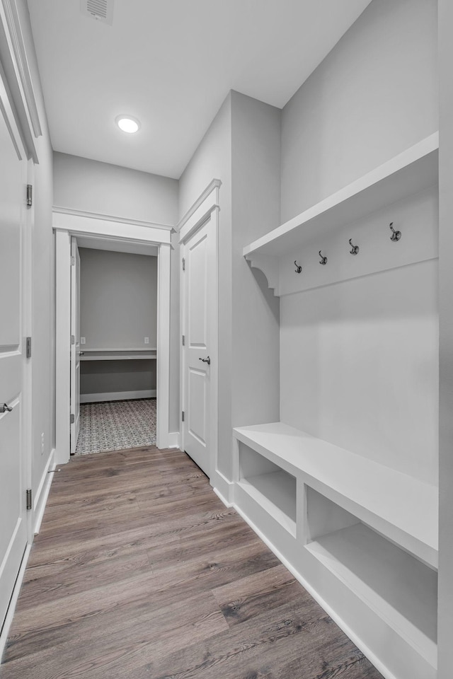 mudroom with visible vents, baseboards, and wood finished floors