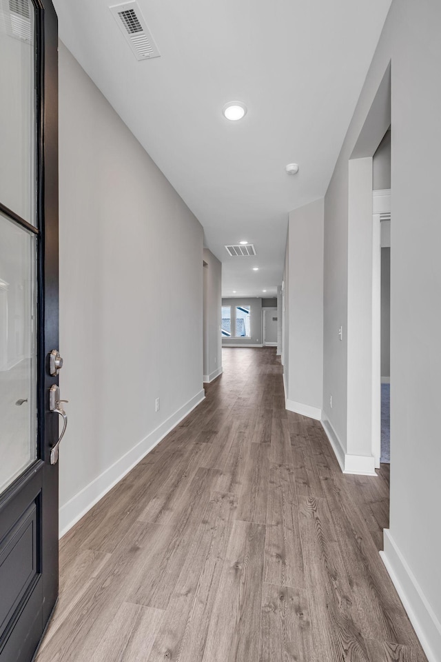 foyer entrance with wood finished floors, visible vents, and baseboards