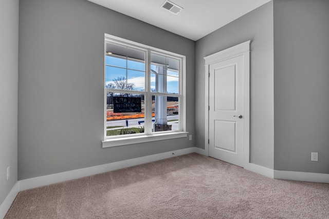 carpeted empty room featuring visible vents and baseboards