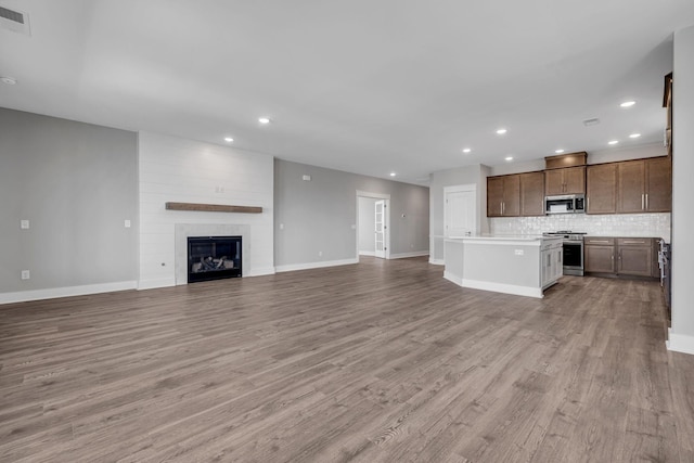 unfurnished living room with recessed lighting, visible vents, baseboards, and light wood-style floors