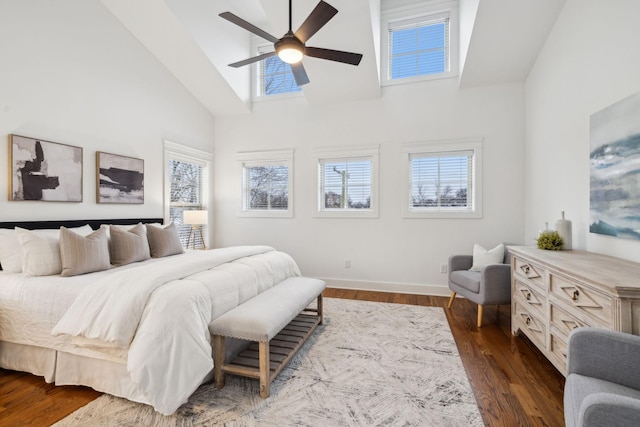 bedroom featuring multiple windows, ceiling fan, dark wood-type flooring, and high vaulted ceiling