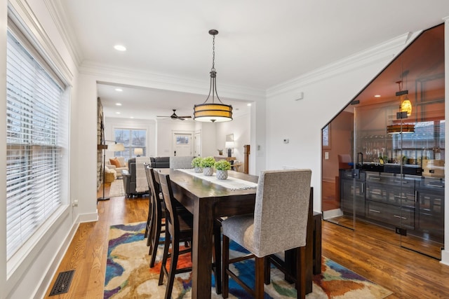 dining area featuring hardwood / wood-style flooring and crown molding