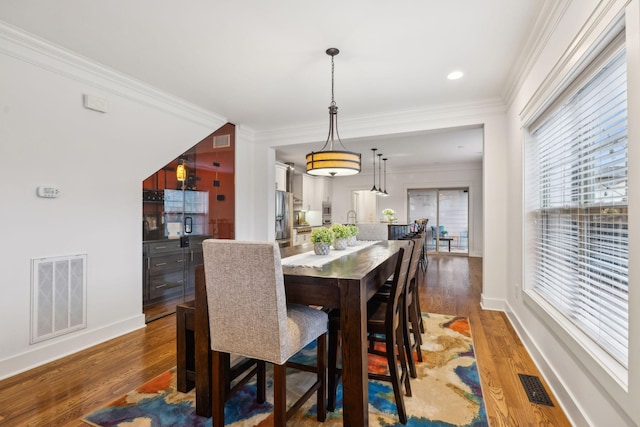 dining room with crown molding and dark wood-type flooring