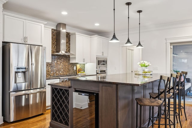 kitchen with a kitchen island, appliances with stainless steel finishes, white cabinets, beverage cooler, and wall chimney exhaust hood