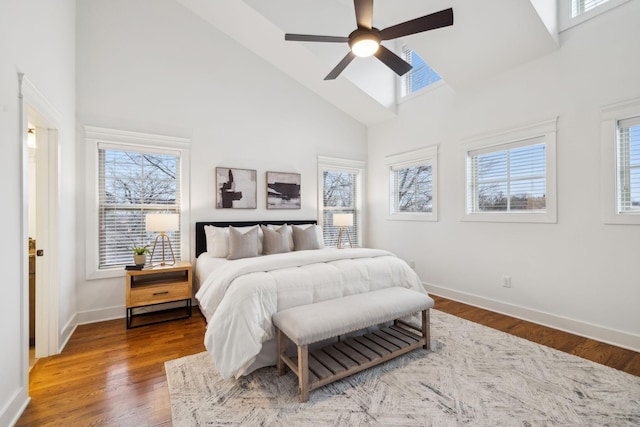 bedroom featuring multiple windows, hardwood / wood-style flooring, and high vaulted ceiling