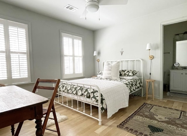 bedroom with connected bathroom, ceiling fan, and light wood-type flooring