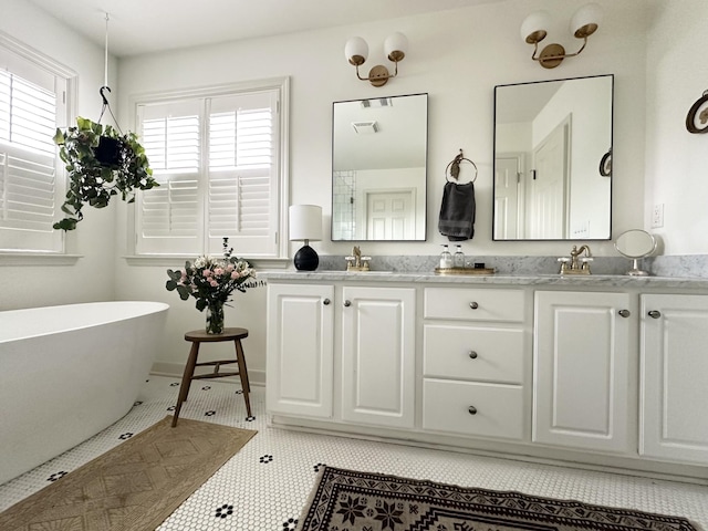 bathroom featuring a bathing tub, vanity, and tile patterned floors