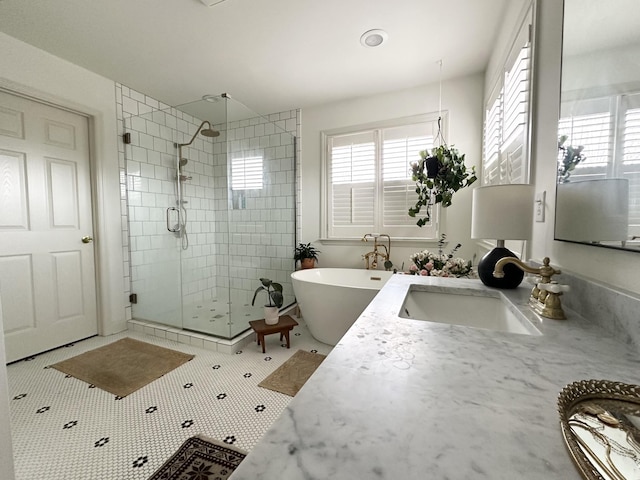 bathroom with a healthy amount of sunlight, plus walk in shower, tile patterned flooring, and vanity