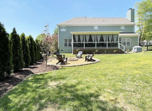 back of house with a yard, a fire pit, a sunroom, and central air condition unit