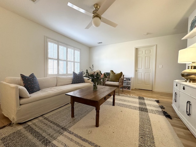 living room with ceiling fan and light hardwood / wood-style flooring