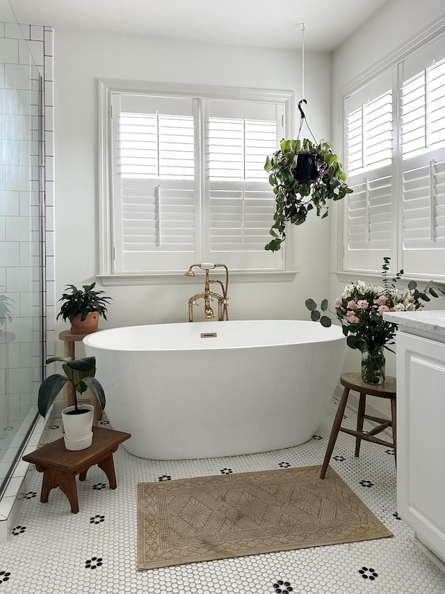 bathroom with a tub to relax in and tile patterned flooring