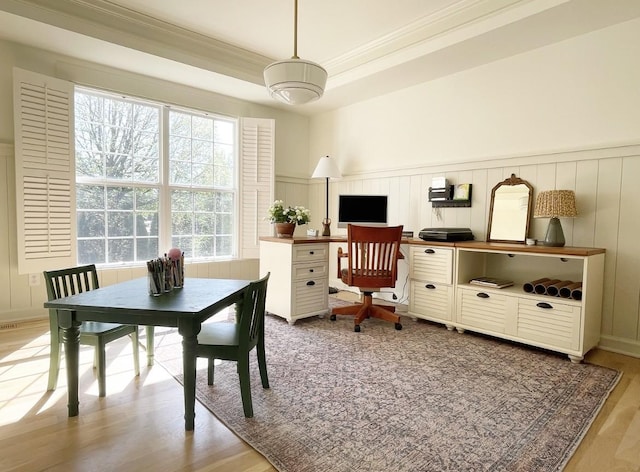 dining area featuring ornamental molding and light hardwood / wood-style flooring