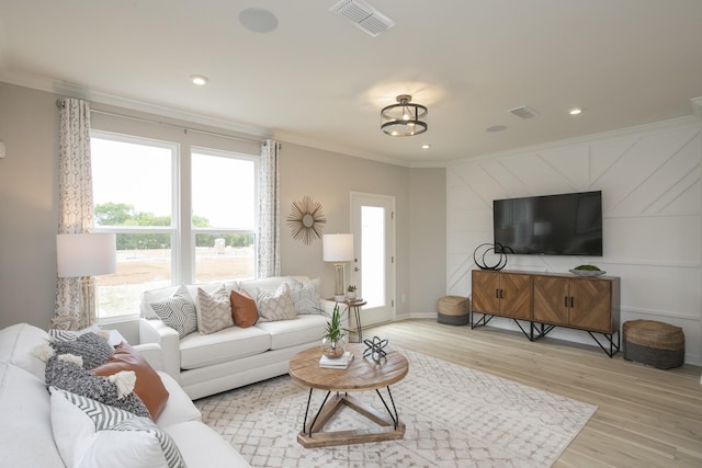 living room featuring crown molding and light wood-type flooring