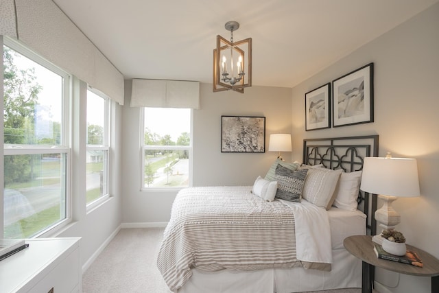 carpeted bedroom with an inviting chandelier