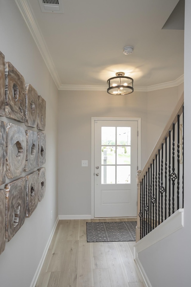 doorway featuring ornamental molding and light hardwood / wood-style floors