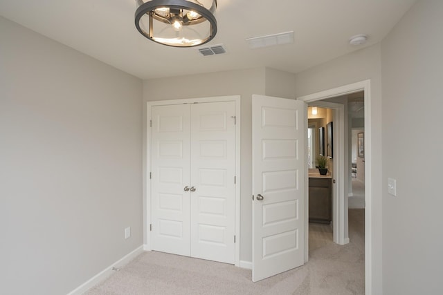 unfurnished bedroom with a closet and light carpet