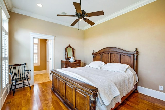 bedroom featuring dark wood-type flooring, ornamental molding, and ceiling fan