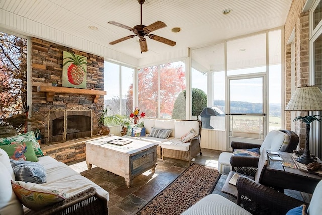 sunroom / solarium with ceiling fan, wood ceiling, and a fireplace