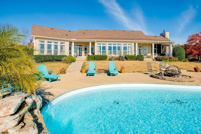 view of swimming pool featuring a patio area and an outdoor fire pit