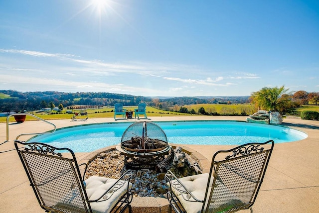 view of swimming pool with a fire pit and a patio area