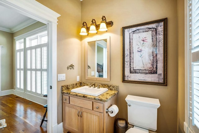 bathroom with vanity, crown molding, toilet, and hardwood / wood-style flooring