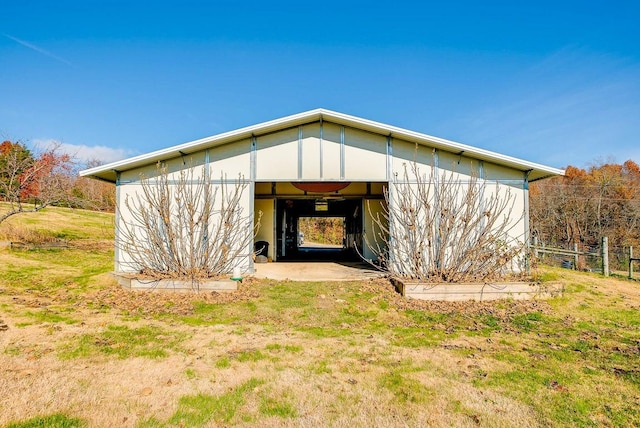 back of property featuring an outbuilding and a lawn