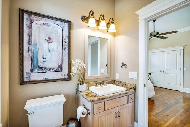 bathroom featuring vanity, ceiling fan, hardwood / wood-style flooring, and toilet