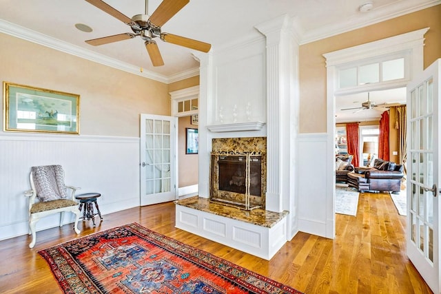 living room featuring ornamental molding, ceiling fan, light hardwood / wood-style floors, and french doors